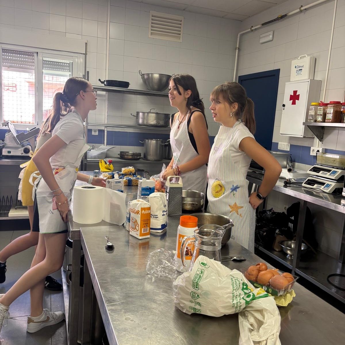 Alumnas con los delantales confeccionados en el taller de upcycling, preparando los ingredientes